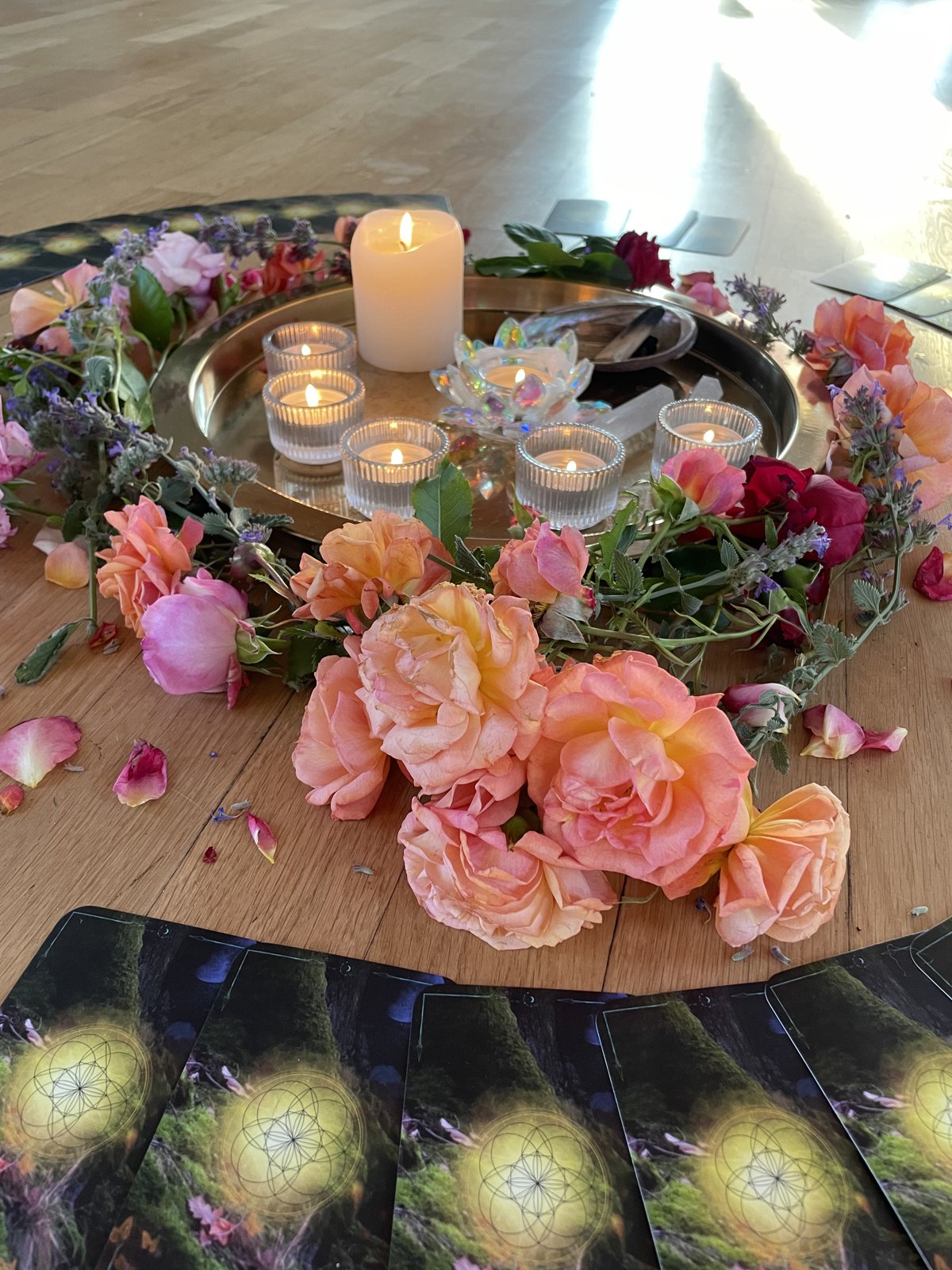 Blumenkreis mit Rosen und Kerzen auf dem Holzboden